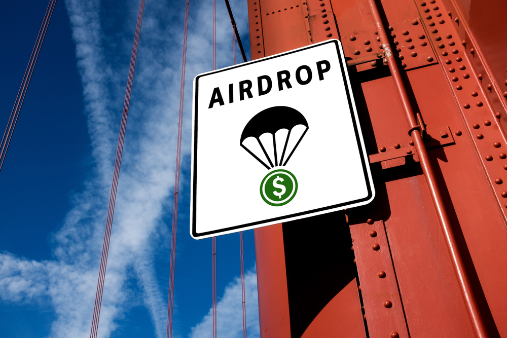 Cryptocurrency free token distribution concept - traffic sign board, AIDROP text with a parachute carrying green dollar symbol, on a metal chain bridge post with blue sky in background