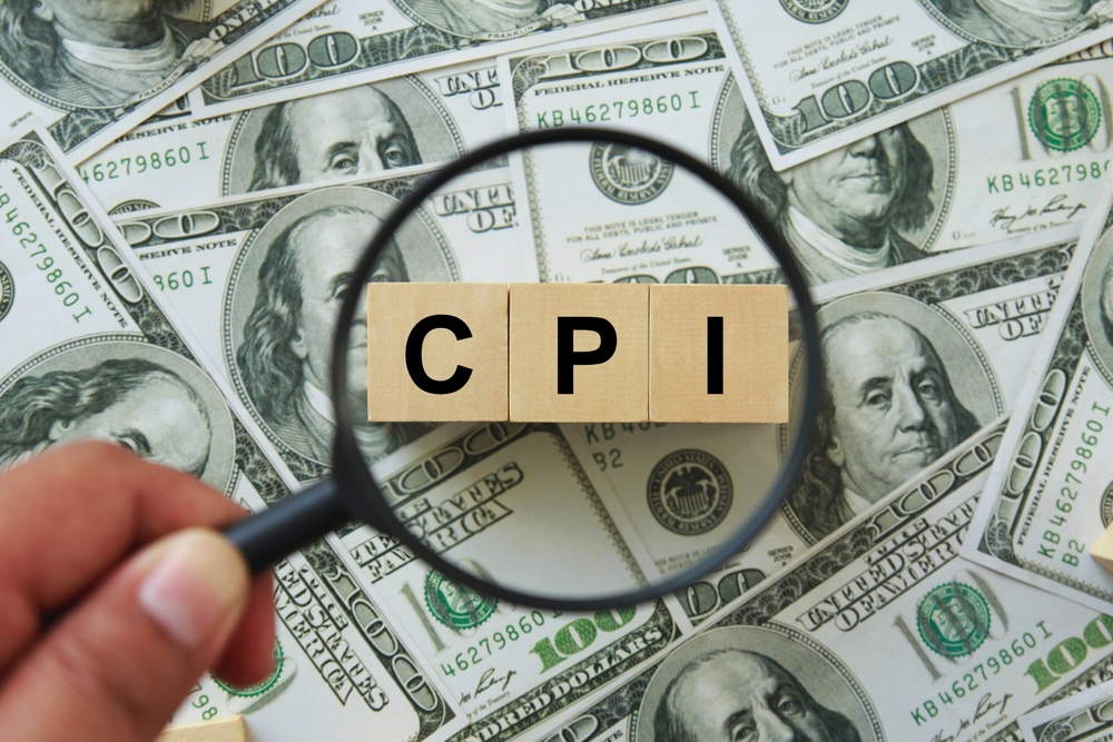 CPI, consumer price index symbol. hand holding magnifying glass investigating wooden block with words CPI, consumer price index on dollar bills. Business and CPI, consumer price index concept.