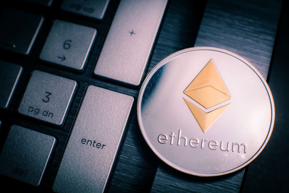Ethereum cryptocurrency (crypto currency). Silver Ethereum coin with gold Ethereum symbol on a laptop keyboard next to the Enter key