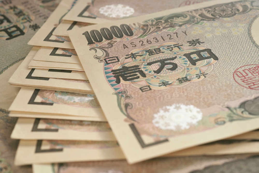 10000 yen Japanese notes. Background or wallpaper with reduced contrast and color saturation. A bundle of bills. Backdrop on the theme of banks, finance and the economy of Japan