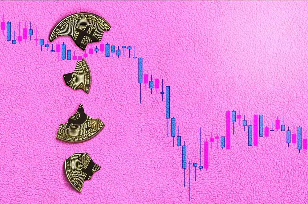 Broken bitcoin lies in the background of the falling chart of the cryptocurrency rate. Pastel pink background. Flat lay top view. The fall and collapse of the course of crypto currency