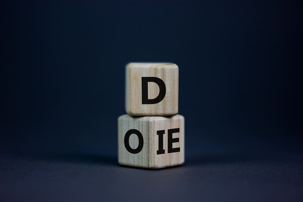 Do or die symbol. Fliped cubes and changed the word 'die' to 'do' or vice versa. Beautiful grey background. Business and do or die concept. Copy space.