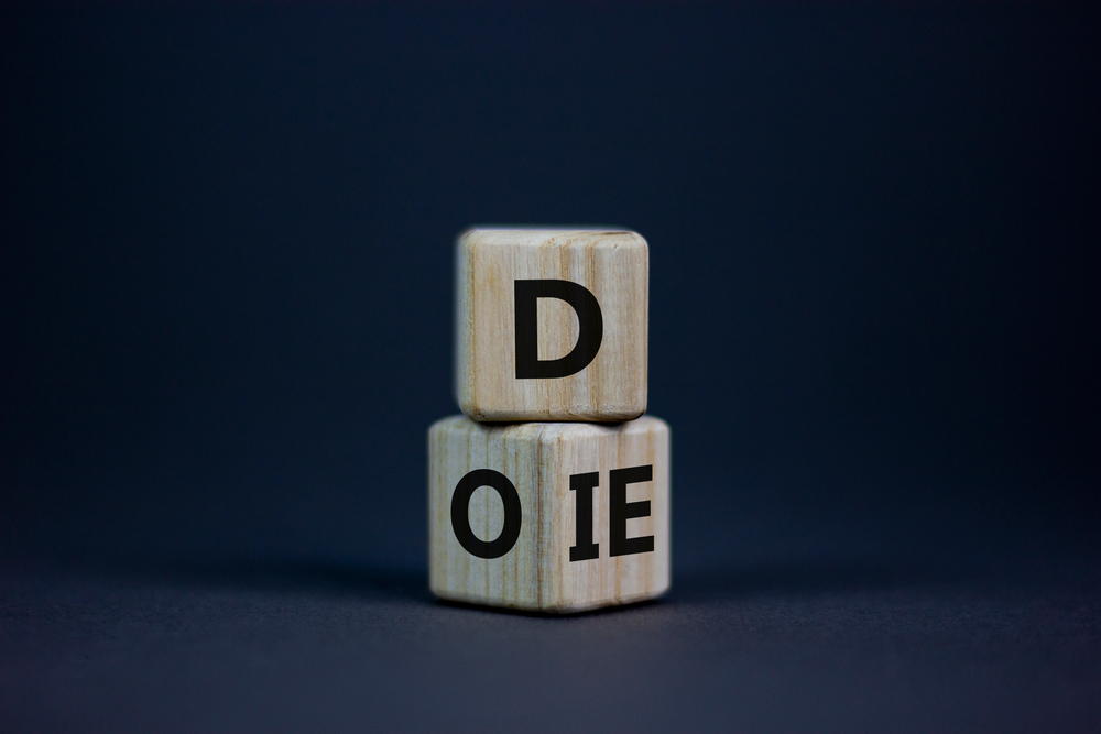 Do or die symbol. Fliped cubes and changed the word 'die' to 'do' or vice versa. Beautiful grey background. Business and do or die concept. Copy space.