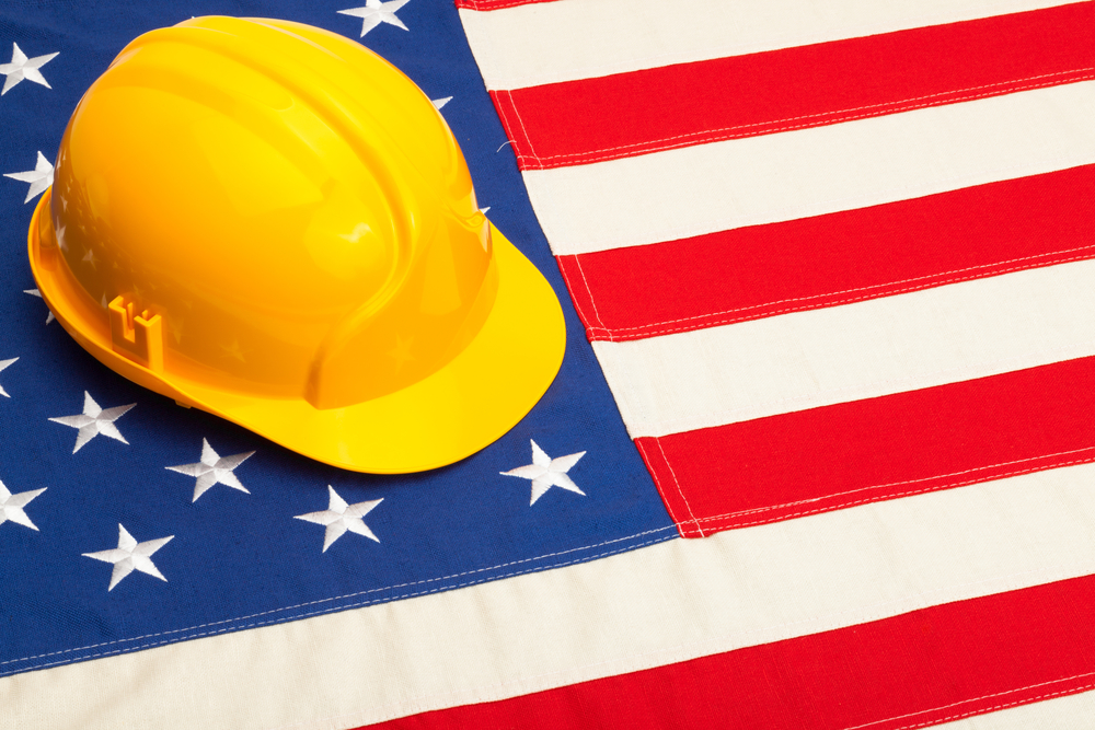 Construction helmet laying over USA flag - studio shoot
