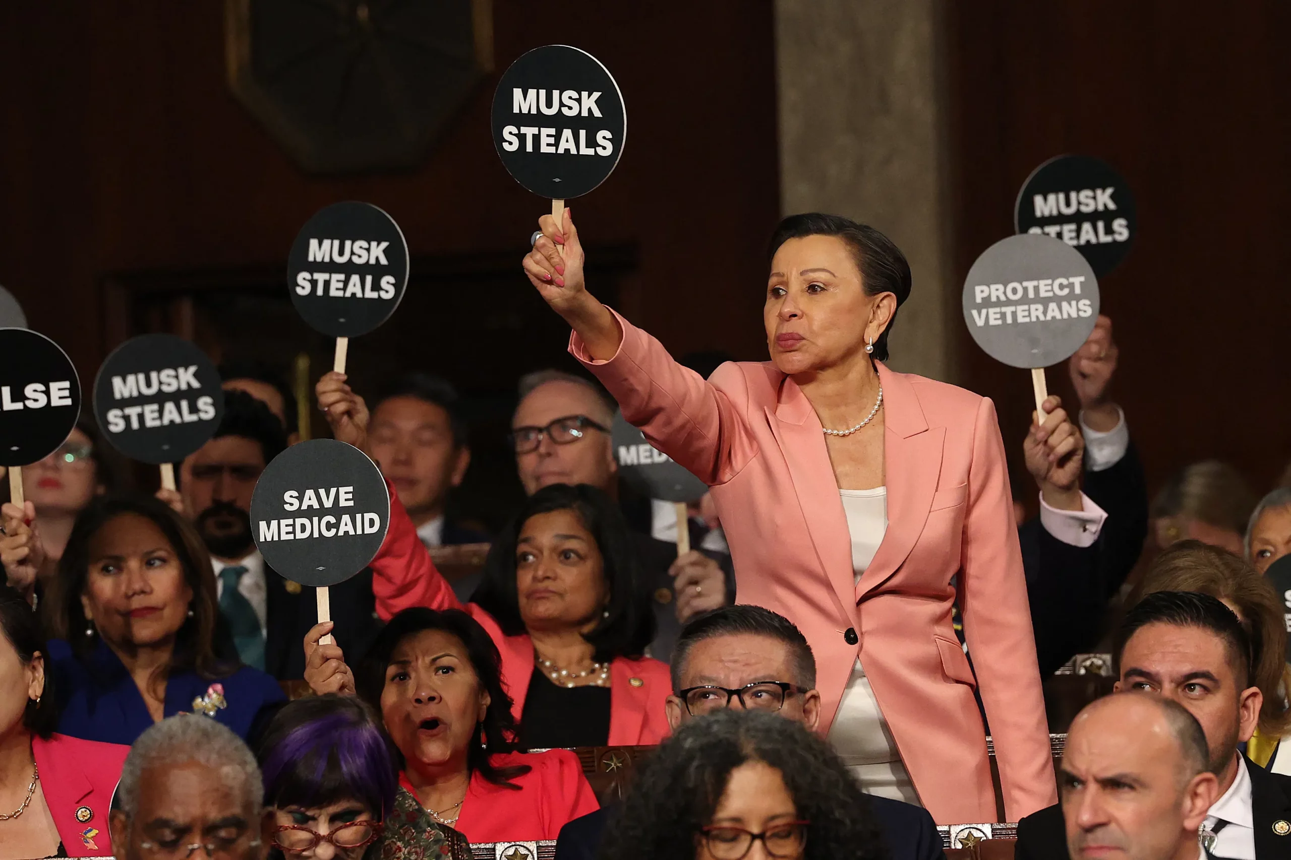 New York Democratic Rep. Nydia Velázquez and other Democrats hold "Musk Steals" protest signs as President Trump speaks during his address to a joint session of Congress on March 4. Photo: Win McNamee/POOL/AFP via Getty Images